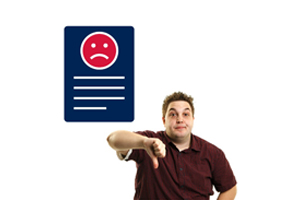 Image of a male putting his thumb down next to a piece of paper with a frowning face on it 