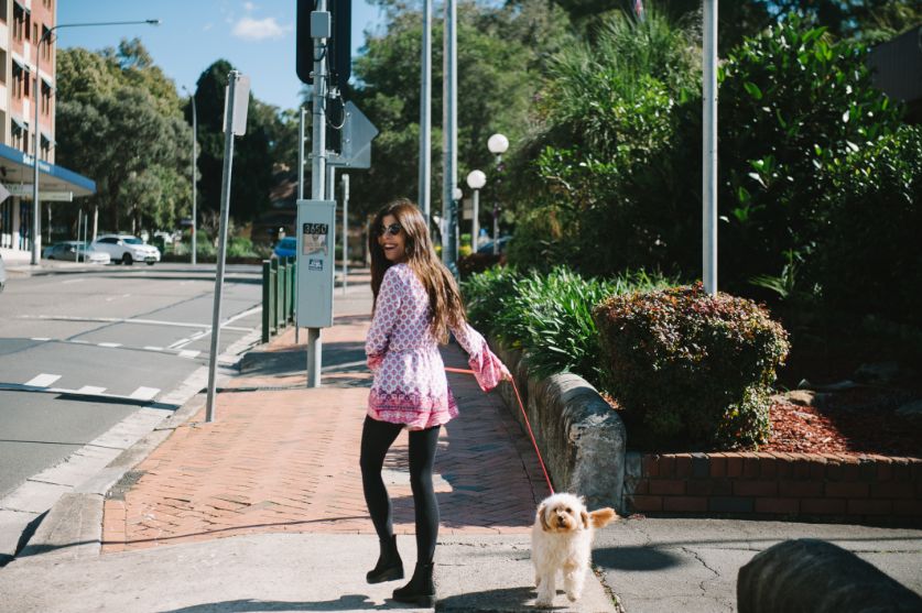 A photo of Natasha walking a small white dog