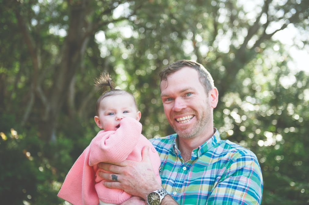 A picture of caseworker Joel holding a baby girl smiling