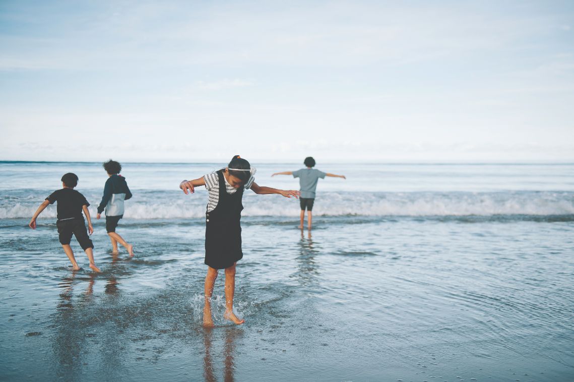 Four children playing at the beach 
