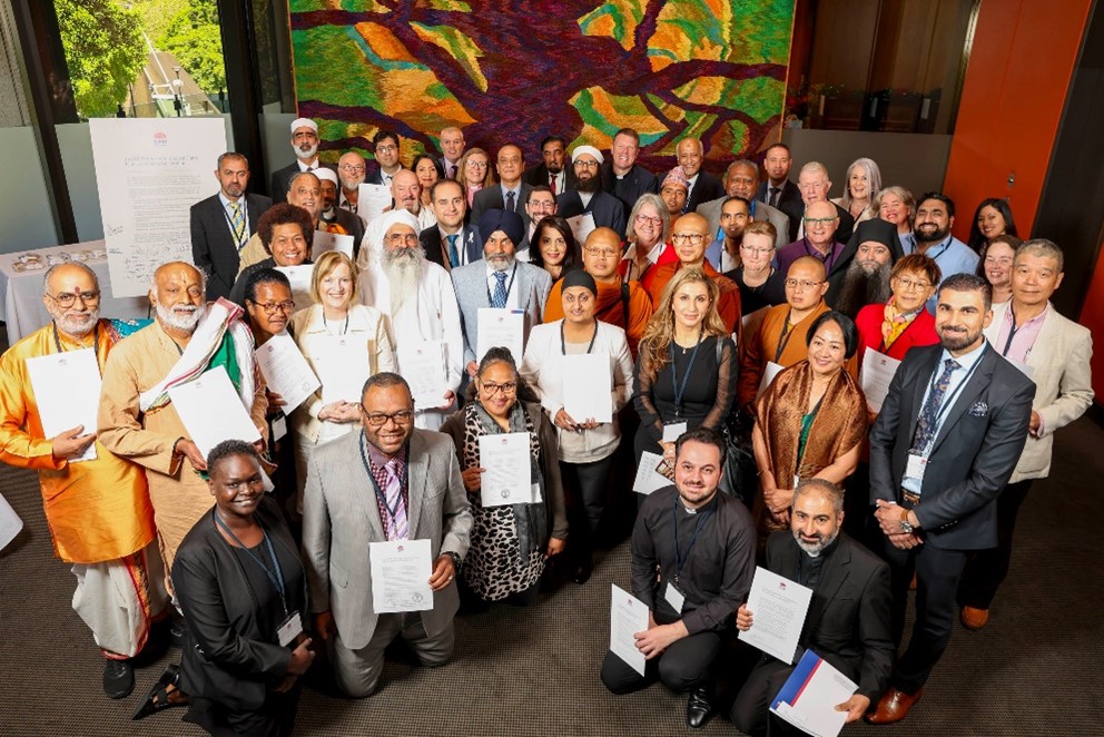 A group photo of all the religious and faith leaders holding their signed declaration.