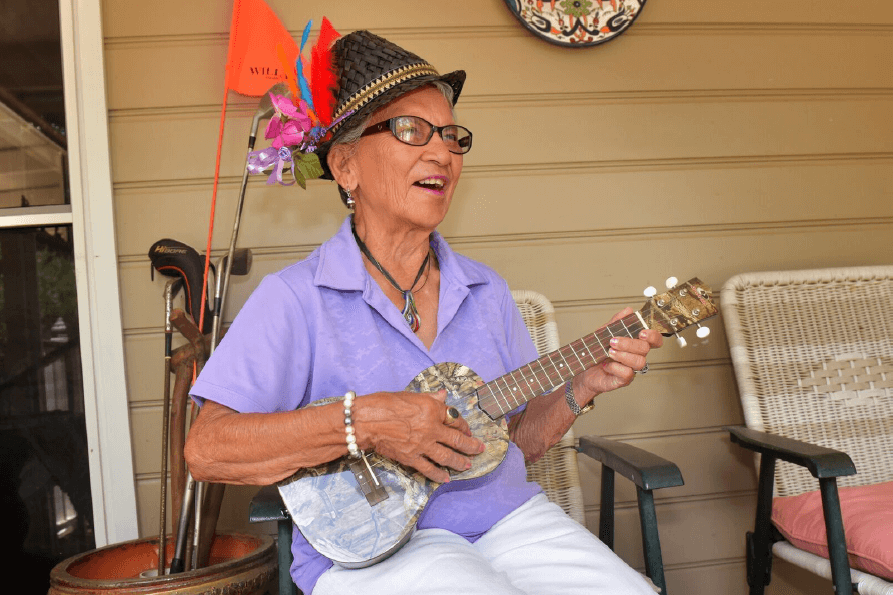 Rita Lucas playing guitar on porch