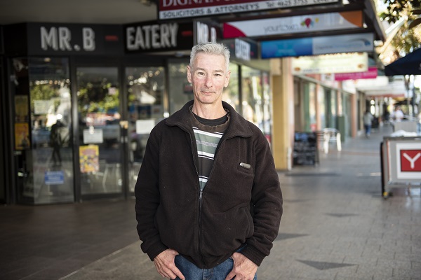 Garry pictured facing the camera while standing in front of local stores. 